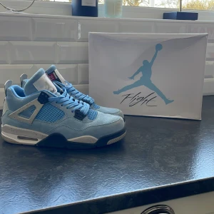 Nike Air Jordans 4 university blue  - Snygga Nike Air Jordans university blue med svarta och vita detaljer och tyget på skorna är mocka. Skorna har en rund tå och klassisk snörning. Skorna är i storlek 44 och är otroligt bra skick 9/10 som nya! Följs med box och allt precis som ett helt par nya skor! Perfekta för dig som vill ha en stilren och sportig look 👀super bra pris ✅