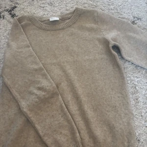 Beige tröja från VILA - Säljer en stilren beige tröja från VILA. Tröjan har en rund halsringning och långa ärmar med ribbade muddar. Perfekt för en avslappnad och bekväm stil.