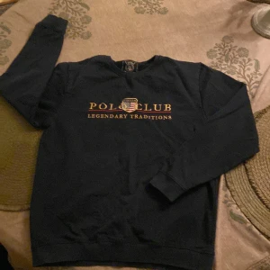 Svart tröja från Mason Polo Club - Säljer en svart tröja från Mason Polo Club med texten 'Polo Club Legendary Traditions' på framsidan. Tröjan har långa ärmar och en rund halsringning. Perfekt för en stilren och avslappnad look. Kan passa barn som har storlek 170 den kan också passa till storlek S.