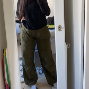 Olivgröna parachute byxor från Pull&Bear - Säljer ett par olivgröna byxor från Pull&Bear. Byxorna har en loose passform och är tillverkade i bomull. Perfekta för en avslappnad stil.