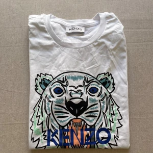Kenzo - En fin vit kenzo t-shirt med tryck. Priser kan alltid diskuteras! Plagget är närmare M än L.  - Oanvänd - Kvitto saknas!