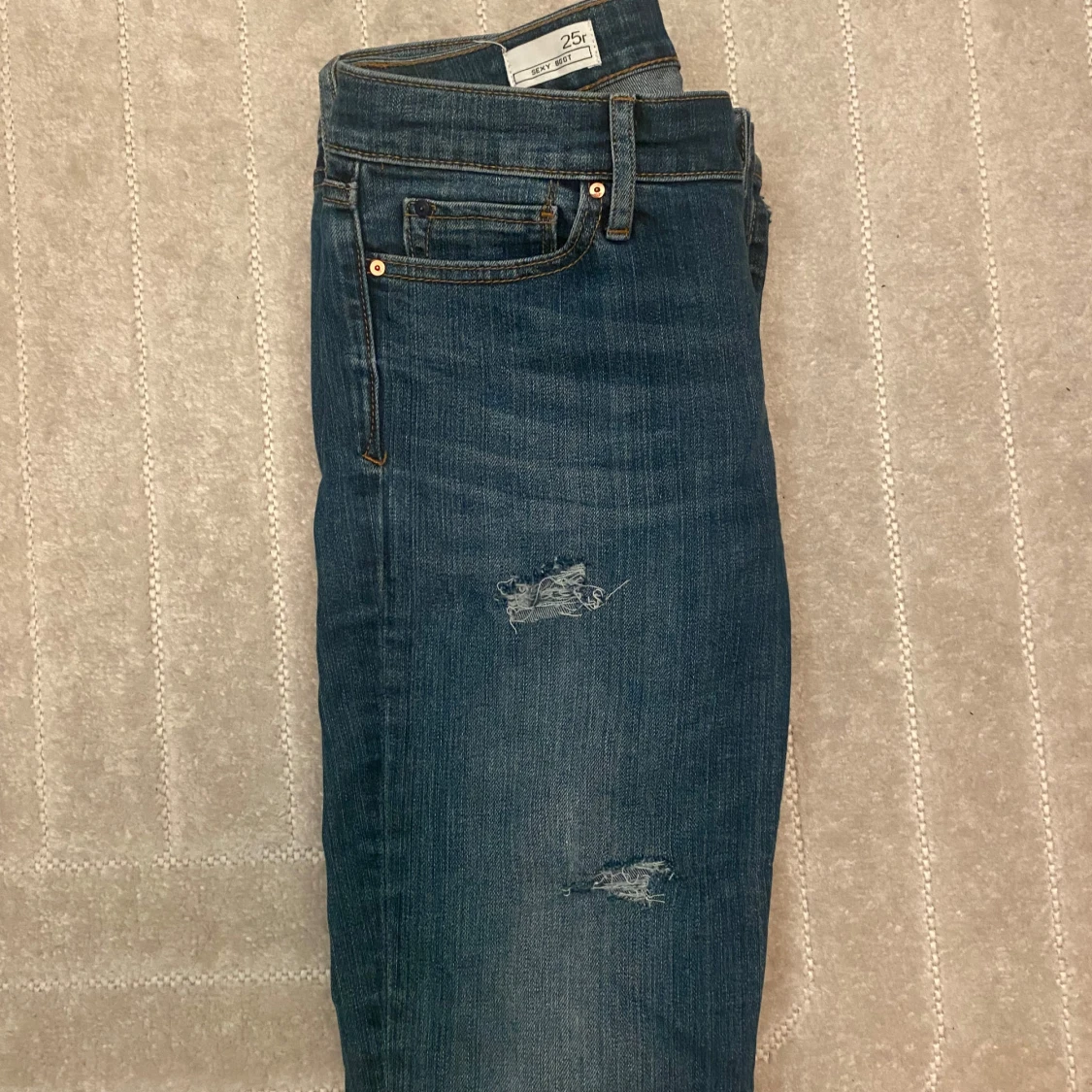 Blå jeans med slitningar