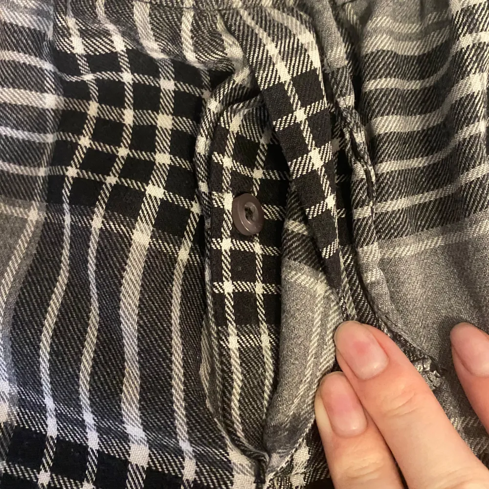 Säljer ett par bekväma svartvitrutiga byxor med elastisk midja och snörning från man avdelningen . Byxorna har en klassisk rutig design och är gjorda i ett mjukt material.. Farkut & Housut.