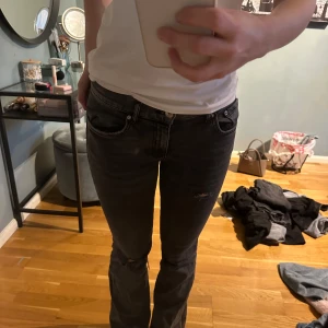 Svarta jeansbyxor - Snygga svarta jeansbyxor med en tight passform. De har en klassisk femficksdesign och en diskret slitning på ena benet. Perfekta för en stilren look.