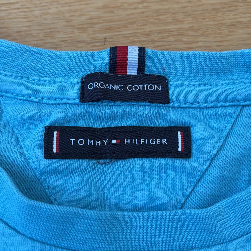Snygg blå t-shirt från Tommy Hilfiger i ekologisk bomull. Den har korta ärmar och ett stort tryck med logotypen på framsidan. Perfekt för en avslappnad stil.. T-paidat.