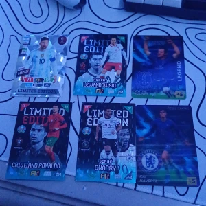 Fotbollskort Limited Edition - Samling av Limited Edition fotbollskort från Panini. Inkluderar kort med spelare som Messi, Lewandowski, Ronaldo, Gnabry, Havertz och Rooney. Perfekt för samlare och fotbollsfans som vill ha exklusiva kort i sin kollektion. De är 4 limited edition 2 bonus är prutbar vid snabb affär Skriv om du har några frågor eller funderingar 
