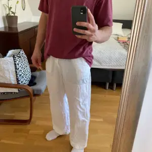 Säljer ett par vita linnebyxor från Weekday. De har en avslappnad passform med knapp och dragkedja i midjan. Perfekta för varma dagar med sitt lätta och luftiga material.