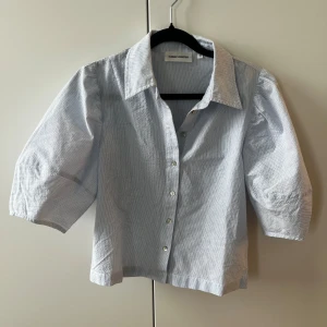 Blus från Carin Wester - Blå/vit randig blus med puffärmar. Från Carin Wester. Använd en gång. Storlek 34.