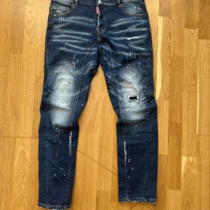 Jeans från Dsquared2 - Snygga jeans från Dsquared2 med en unik tvätt och slitna detaljer. De har en klassisk femficksdesign och en cool patch på baksidan. Perfekta för dig som vill ha en edgy stil (storlek 52). 