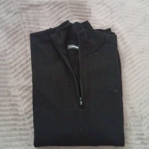 J Lindeberg half zip  - Säljer en snygg oanvänd halv zip tröja från J Lindeberg. Den är köpt nyligen och har aldrig används. Kvitto finns. 