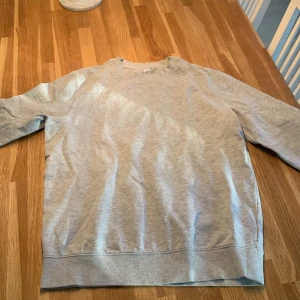 Grå sweatshirt - Säljer en enkel och stilren grå sweatshirt i storlek M. Perfekt för en avslappnad look. Tröjan har långa ärmar och en rund halsringning. Pris kan diskuteras!