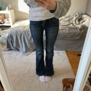 Mörkblå bootcut jeans - Snygga mörkblå bootcut jeans med klassisk femficksdesign. Perfekta för en avslappnad stil och passar bra med sneakers eller stövlar. Jättesnygga detaljer. Lågmidjade