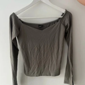 Grå långärmad topp från gina - Snygg grå långärmad topp från gina  med en v-ringad design. Perfekt för en stilren look. Passar bra till både jeans och kjol.