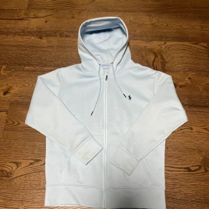 Ljusblå zip hoodie från Ralph Lauren - Säljer en ljusblå hoodie från Ralph Lauren i mycket bra skick då den knappt är använd. Skriv vid frågor och funderingar 