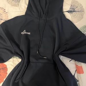 Svart hoodie från Dazy  - Säljer en marinblå hoodie från Dazy med texten 'MAKE AWSOME' tryckt på bröstet. Den har en klassisk design med dragsko i huvan och en stor magficka. Perfekt för en avslappnad stil.