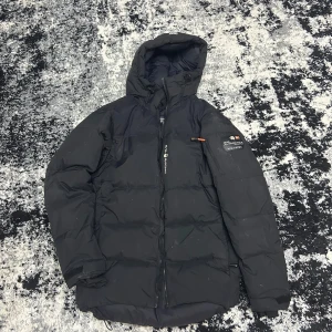 Svart dunjacka från Sail racing  - Säljer en svart dunjacka från sailracing perfekt för kalla dagar. Skick 7/10 var lite för stor.