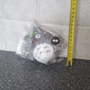 Grå Totoro nyckelring - Söt grå Totoro nyckelring med broderade detaljer och en liten svart figur. Perfekt som accessoar för att ge en personlig touch till dina nycklar eller väska.