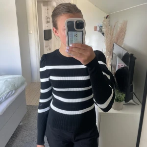 Svartvit randig tröja - Säljer en svart och vit randig långärmad tröja. Tröjan har en slim passform och markerade axlar. Tröjan är även lite ribbad i materialet. Jag har bara använt tröjan några gånger. Ser ut som ny!