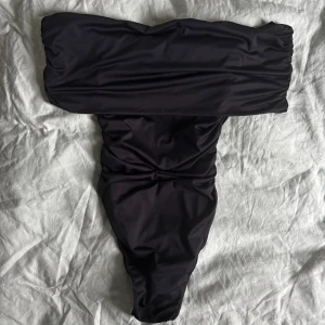 Svart off-shoulder topp / body - Snygg svart off-shoulder body. Funkar till fest och till vardags! Står ingen storlek men skulle säga S/XS.  Har satt en tejp bit i insidan av tyget för att håll den på plats, får tyvärr inte bort tejpen nu, men syns ju självklart inte! Annars är toppen i mycket fint skick, endast använd 1-2 gånger ❣️❣️❣️