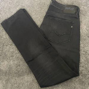 Svarta Replay Rocco jeans  - Säljer ett par svarta Replay Rocco jeans i comfort fit. Jeansen har klassisk femficksdesign, raka ben och snygga detaljer på bakfickan. Tillverkade i mjukt jeansmaterial som sitter skönt hela dagen. Skriv vid frågor eller funderingar