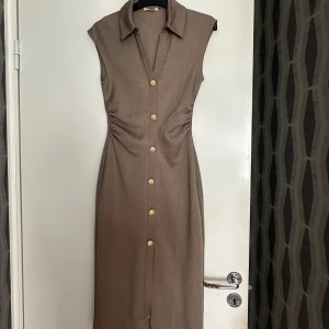 Zara klänning - En superfin klänning från Zara med guld knappar i storlek S. Använt endast en gång. Passar perfekt till allt🤎  Köpt för 389kr
