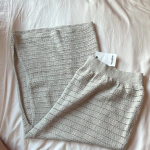 Beige stickad långkjol - Superfin beige stickad långkjol från Pull&Bear med snygg slits på sidan. Kjolen har en elastisk midja och är perfekt för att vika ner och göra lowwaist! Ny med prislapp, aldrig använt