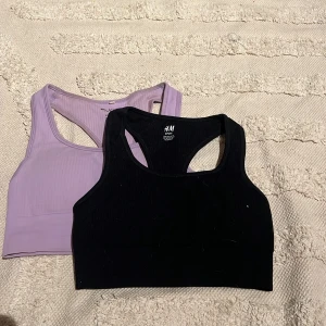 2 sportiga ribbade linnetoppar H&M - Två sportiga linnetoppar från H&M, en i svart och en i ljuslila. Båda är ribbade och har brottarrygg för extra support. Perfekta för träning eller chill dagar. Säljes tillsammans, båda i stretchigt och mjukt material.