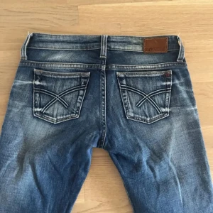 Blå jeans från Big Star med broderade fickor - Säljer ett par klassiska blå jeans från Big Star med snygga slitningar och broderade bakfickor. Jeansen har normal passform och raka ben/bootcut