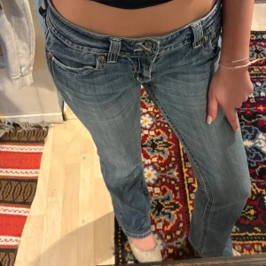 Miss Me ljusblå bootcut jeans strl 32 - Kom privat för billigare Säljer ett par ljusblå jeans från Miss Me med snygg bootcut-modell och låg midja. Jeansen har coola detaljer med dubbla knappar och broderad bakficka med bling och kors. Klassisk femficksdesign och slitningar för en trendig look.