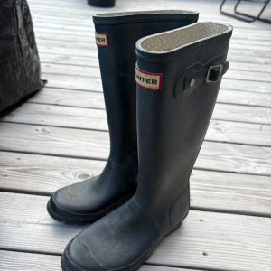 Marinblå Hunter stövlar i gummi - Klassiska svarta stövlar från Hunter, ganska gamla men inte så mycket använda. 