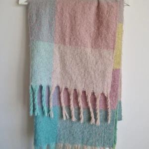 Pastellrutig fluffig halsduk med fransar - Mjuk och stor halsduk i pastelliga rutor med fransar i kanten. 