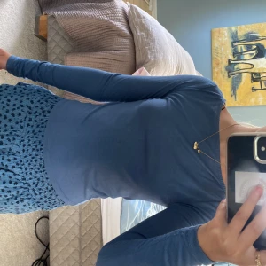 Blå långärmad tröja från H&M - En mjuk blå långärmad tröja från H&M i stretchigt material. Fint skick och nästan aldrig använd. Tröjan har en enkel, rund/båtringad halsringning och sitter tajt mot kroppen. Perfekt att styla med jeans eller kjol för en clean look. Materialet är mjukt och består av polyester, viskos och elastan. 