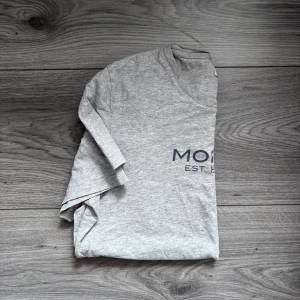 Grå Morris T-shirt, stl M, ny utan prislapp - Skicka gärna vad du tycker att t-shirten är värd, jag är öppen för bud, skicka gärna ett! Grå T-shirt från Morris i storlek M, ny utan prislapp. Klassisk passform med Morris-tryck framtill, gjord i mjuk bomull med riktigt skön kvalitet. Perfekt för dig som gillar stilrena och tidlösa plagg med premiumkänsla. Nypris ca 600 kr, här har du möjlighet att få den till ett mycket bättre pris, 249 kr! Kika gärna in min profil, jag lägger upp fler liknande plagg löpande! Morris t-shirt herr ny oanvänd M