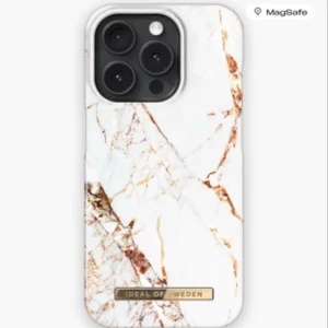 Carrara Gold mobilskal i marmorlookm  - Snyggt mobilskal från iDeal of Sweden i Carrara Gold-design med vit bas och guldiga marmordetaljer. Passar iPhone 15 Pro och har en elegant metallogo längst ner. Skalets yta är slät och ger en lyxig känsla till mobilen. Endast provad på mobilen aldrig använd. Matchande magnetisk ring, köpt ihop även den oanvänd. Vid köp av skal gäller priset, vid köp av båda gäller en överenskommelse över vad du är villig att betala för båda☺️