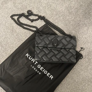 Kurt Geiger quiltad axelväska  - Säljer min svarta väska från Kurt Geiger London, modell The Kensington. Väskan har kedjerem, snyggt rutmönster och örndetalj på locket. Perfekt för dig som vill ha en stilren och trendig väska. Nypris 2650kr 💓