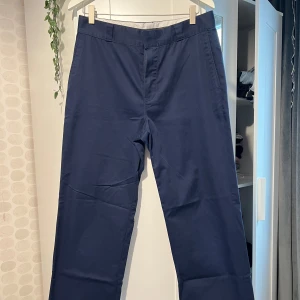 Mörkblå chinos från H&M - Snygga mörkblå chinos från H&M med klassisk passform. Byxorna har raka ben, diskreta sidofickor och bakfickor(inte riktiga) med knapp . Perfekta för en clean och stilren look. Har använt denna ett par gånger