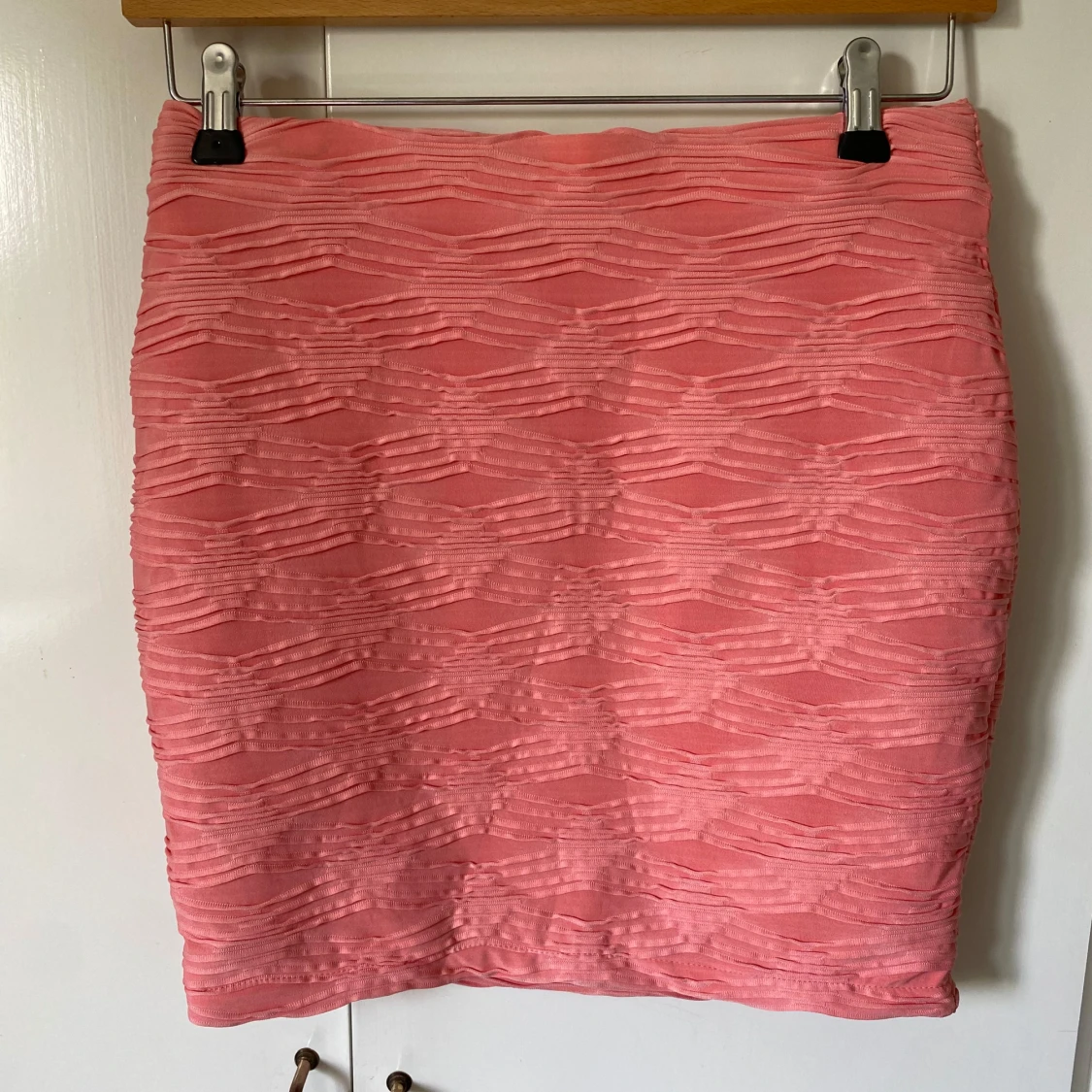 Rosa kortkjol med strukturmönster