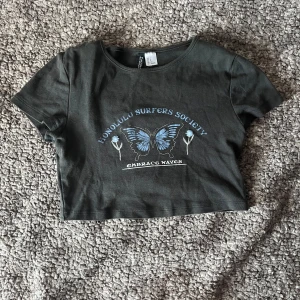 Svart croppad topp med blå fjäril - Aldrig använd bara tvättad.