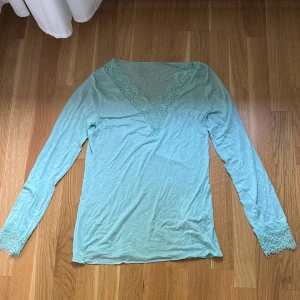 Tourkos långärmad topp från Intimissimi - Superfin tourkos långärmad topp från Intimissimi med v-ringning och spetsdetaljer vid halsringning och ärmslut. Tunn och mjuk och snygg passform och riktigt skön mot huden. Den är aldrig använd💕💕