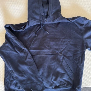 Mörkblå hoodie från Weekday - Säljer en mörkblå hoodie från Weekday i storlek S. Tröjan har huva med snörning och en stor magficka framtill. Materialet är mjukt och skönt, bomull. 