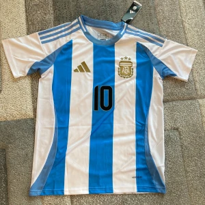 Argentina 2024 Hemmatröja - Säljer en helt ny Argentina landslagströja från 2024 i storlek small (S)  🎯 Messi #10 på ryggen 🪡 Broderad adidas-logga & förbundsemblem 🏷️ Helt ny med tagg kvar  💬 Skicka gärna ett meddelande om du undrar något!