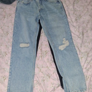 Ljusblå jeans från fsbn denim - Ljusblå jeans från fsbn denim med slitna detaljer på knäna och bakfickan. Klassisk femficksmodell med raka ben och normal passform. Jeansen har hög midja Snygga kontrastsömmar och cool vintagekänsla.