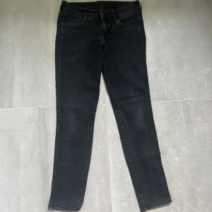 Svarta skinny jeans från H&M - Svarta skinny jeans från H&M med låg midja. Jeansen har klassisk femficksdesign, smal passform och är tillverkade i stretchigt denimtyg för en tajt look. Perfekta till sneakers eller boots och funkar året runt.
