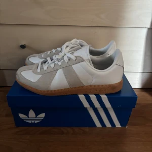 Adidas BW Army sneakers vit/beige - Snygga Adidas BW Army sneakers i vitt skinn med beige mockadetaljer och klassisk gummisula. Skorna har rund tå, snörning och en stilren retrolook som passar perfekt till streetwear. Kommer med originalkartong.