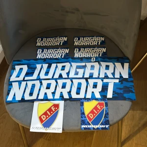 Djurgår'n Norrort - Samling med klistermärken i blått kamouflagemönster och DIF-sköld, perfekt för dig som vill visa ditt stöd för Djurgården och Norrort. Snygga och unika dekaler för unga supportrar att sätta på datorn, mobilen eller cykeln.