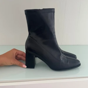 Svarta stövletter med klack - Stilrena och eleganta svarta klackskor i äkta skinn, perfekta för både fest och vardag! 	•	Storlek: 40 	•	Färg: Svart 	•	Klackhöjd: ca 5–7 cm 	•	Material: Skinn  Skorna är i mycket fint skick och otroligt snygga – ett måste i garderoben!  Pris: 200 Kan skickas eller hämtas. 