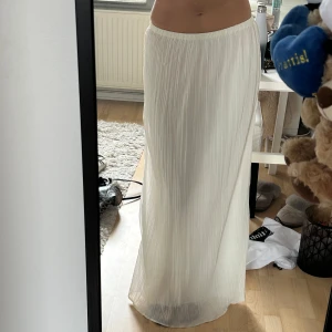 Vit plisserad långkjol - Säljer en superfin vit långkjol med plisserat tyg och elastisk midja😊perfekt i längden för mig som är 175