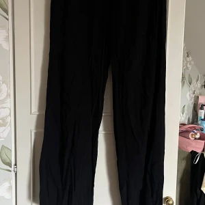 Svarta vida linnebyxor - Säljer ett par svarta linnebyxor med loose fit och rak, vid passform. Byxorna har hög midja och är tillverkade i ett lätt och luftigt linnematerial.