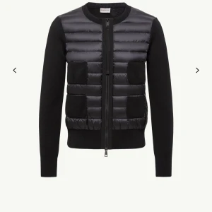 Svart quiltad cardigan jacka från Moncler - INTRESSEKOLL på en svart cardigan jacka från Moncler med quiltad framsida och två fickor. Jackan har långärmade stickade ärmar och dragkedja framtill. Perfekt för dig som vill ha en stilren look med exklusiv känsla.
