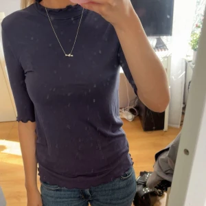 Mörkblå topp med volang  - En mörkblå topp med halvlånga ärmar och volangkant vid hals, ärmslut och nederkant. Super mjuk och strechig, perfekt som chill- och finklädsel. Tveka inte på att fråga om du undrar något! 💌